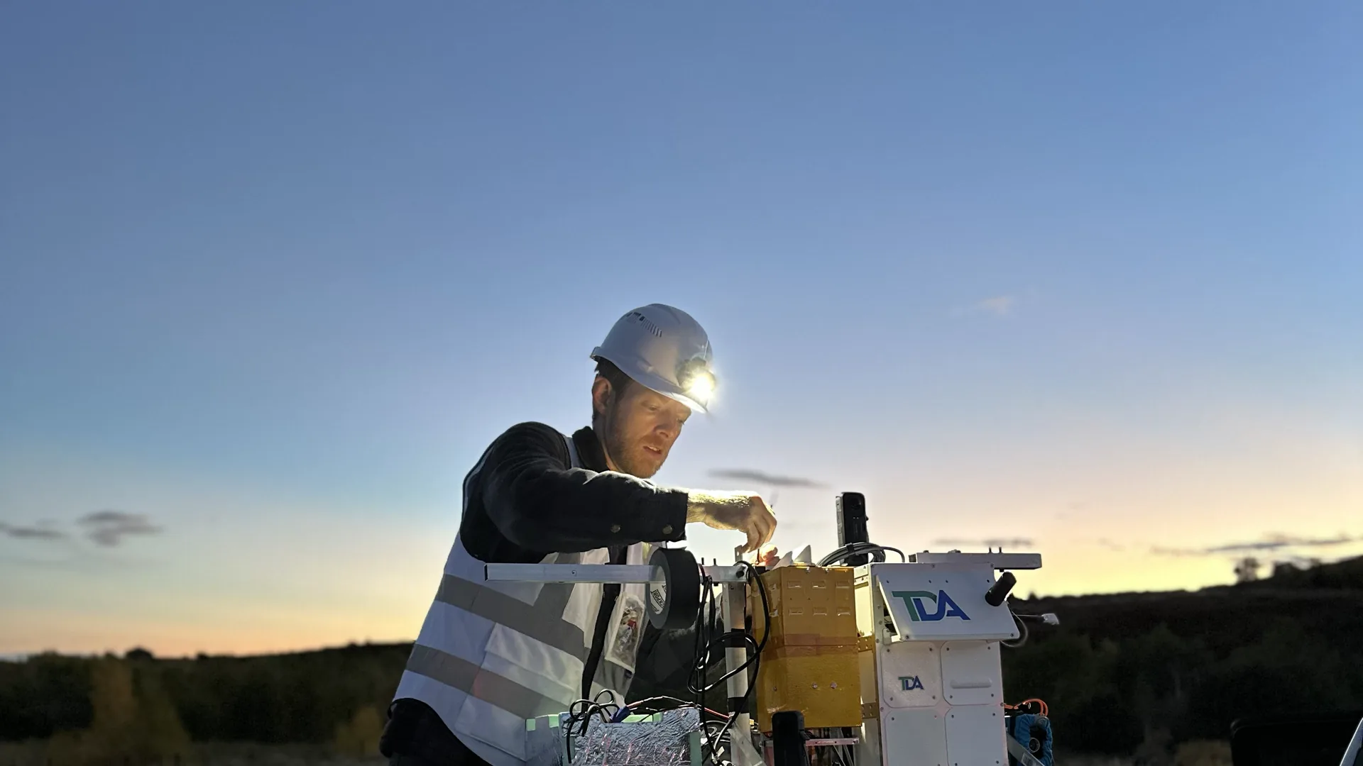 StratoStar engineer integrating payload electronics at dusk before a near-space flight test